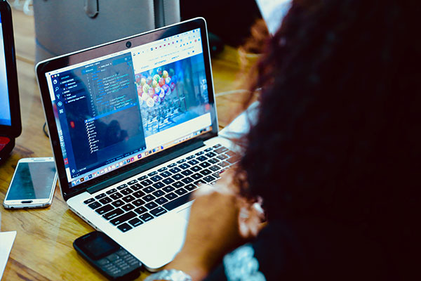 Travail sur ordinateur avec double écran, probablement pour du montage, de la création de contenus ou de la gestion de formations.
