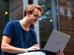 Travail sur ordinateur avec double écran, probablement pour du montage, de la création de contenus ou de la gestion de formations. Formations Kifbody en ligne