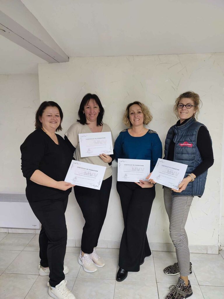 Groupe de femmes debout tenant leur attestation de formation, moment de clôture d’un module ou d’un atelier. MVV (alliance du chi nei tsang et des ventouses) NIVEAU 1