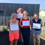 Autre groupe de stagiaires avec leurs certificats en extérieur, ambiance conviviale et fière.