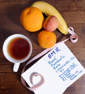 Composition symbolique autour d’une horloge et de couverts, illustrant la notion de chrono-nutrition ou de rythme alimentaire. Formation en ligne : Gain de minceur (perte de poids) en ligne ou en présentiel, Charente Maritime